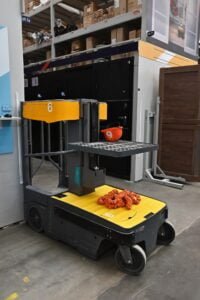 The pallet truck is insulated on white. Industrial car. A forklift truck. Side view of an electric